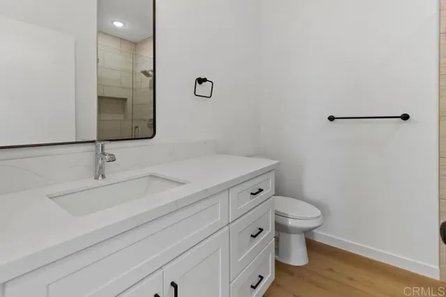 a bathroom with a sink a toilet and a mirror