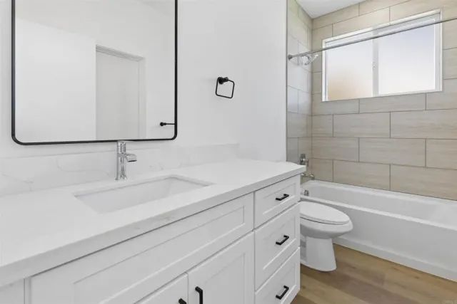 a bathroom with a bathtub shower sink vanity and toilet
