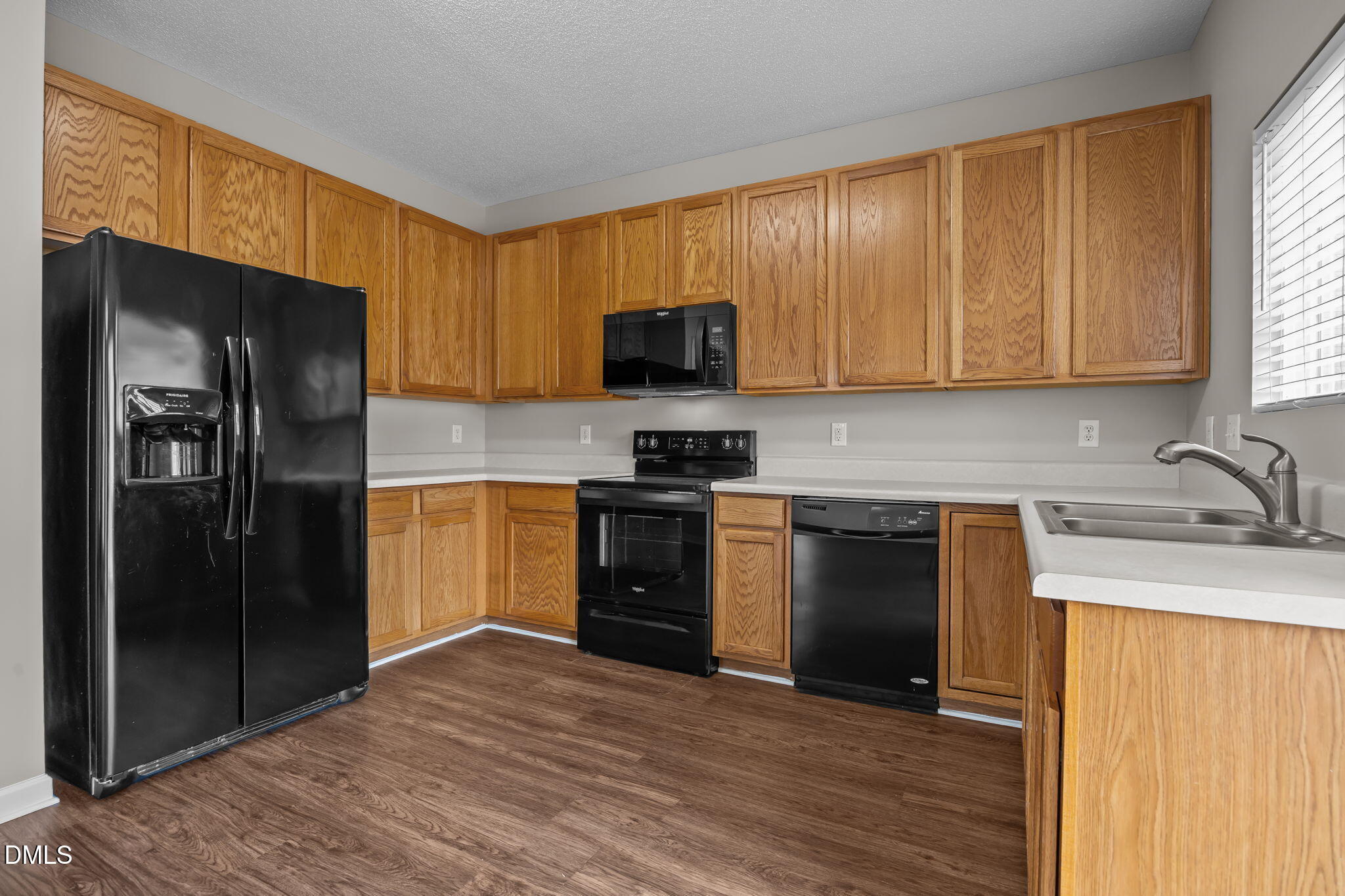 4406 Snowcrest Lane Raleigh, NC 27616 - Photo 13 of 41 a kitchen with granite countertop wooden cabinets a refrigerator and a sink