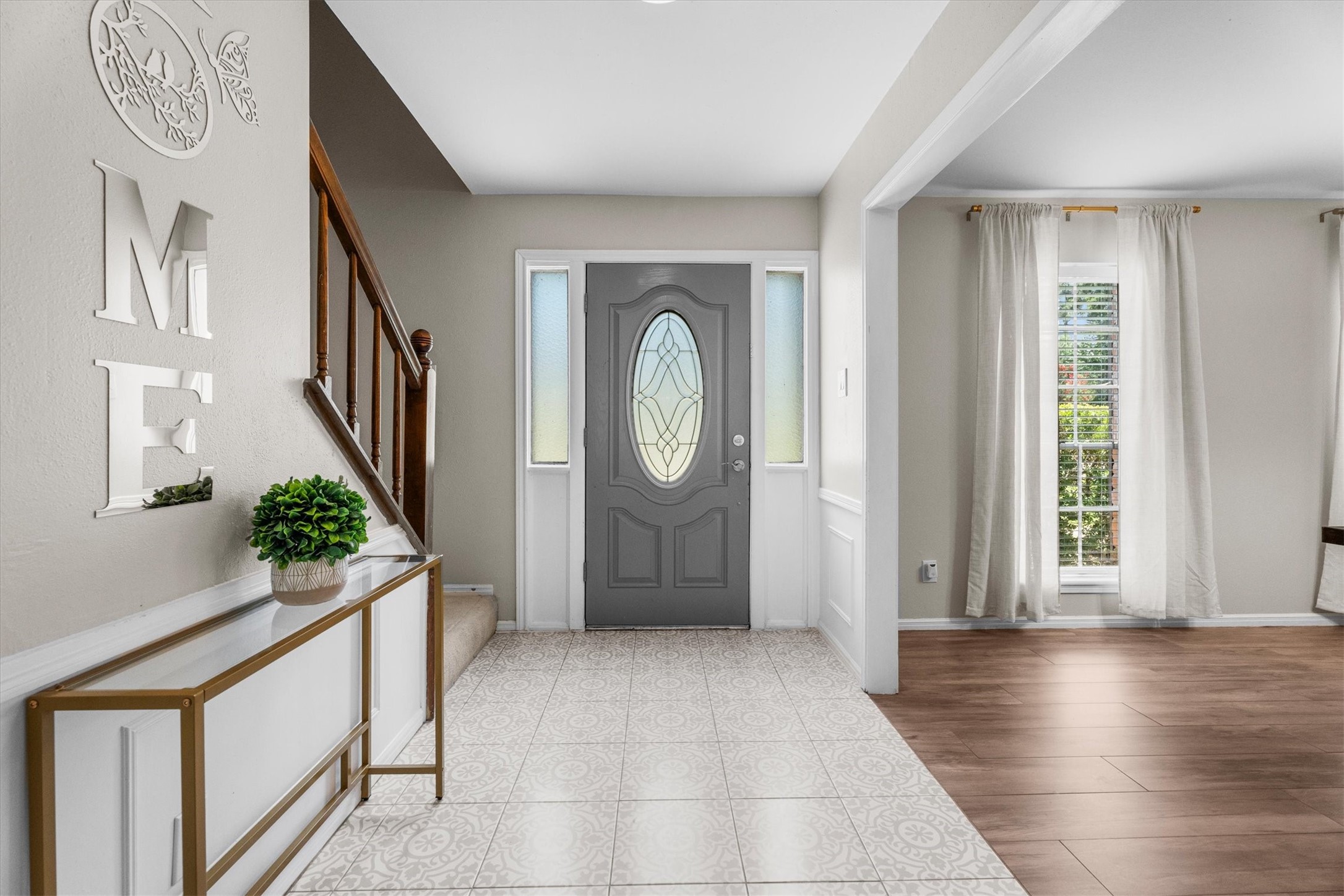 4026 Oxhill Road Spring, TX 77388 - Photo 5 of 40 A bright and welcoming foyer greets you with elegant patterned tile flooring, soft neutral tones, and an abundance of natural light. The open layout offers a seamless introduction to the home's thoughtfully designed living spaces, while the staircase adds warmth and character.