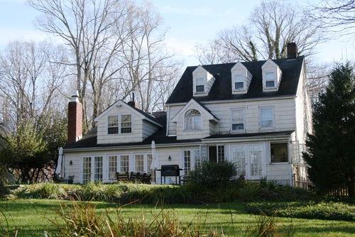 a front view of a house with a garden and trees