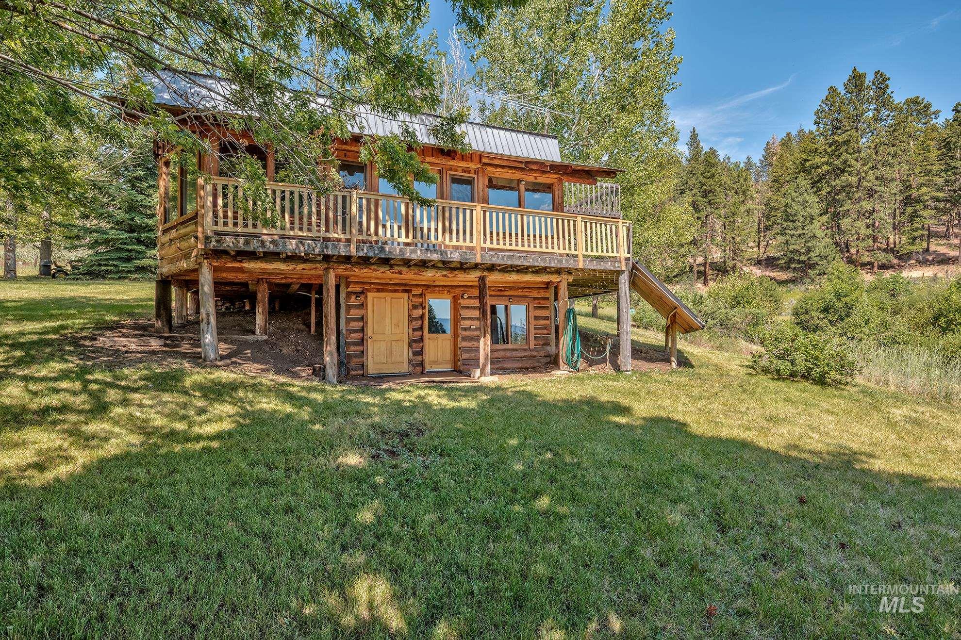 2150 Seid Creek Road Cambridge, ID 83610 - Photo 30 of 50 Multi-level log cabin with a metal roof and an upper-level balcony featuring wood railing