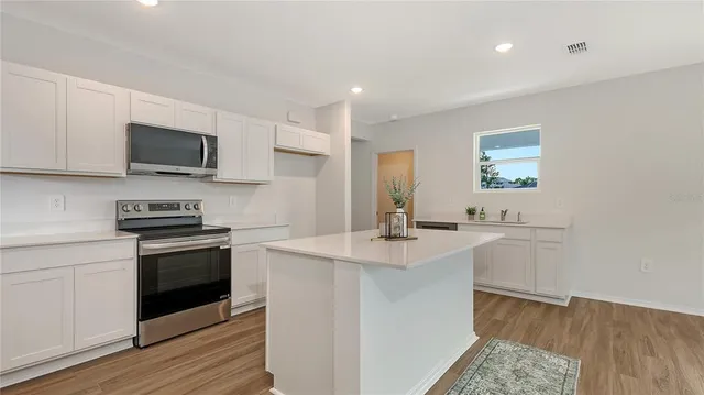 a kitchen with a sink stove and microwave