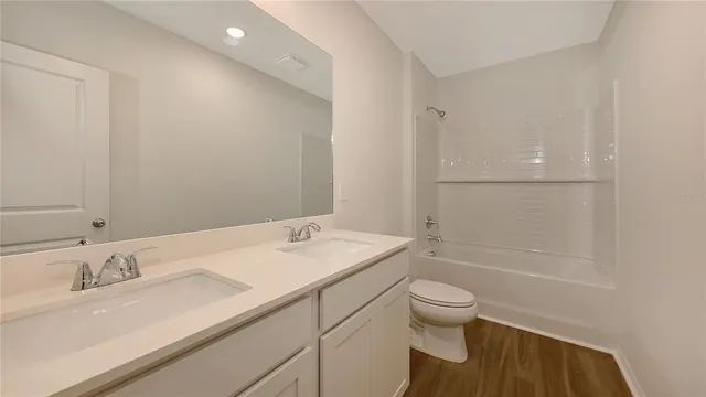a bathroom with a granite countertop sink a toilet and shower