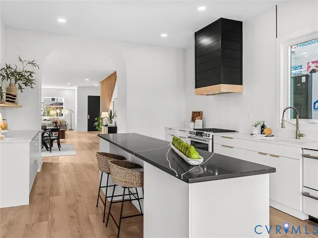 a kitchen with a sink a counter and chairs