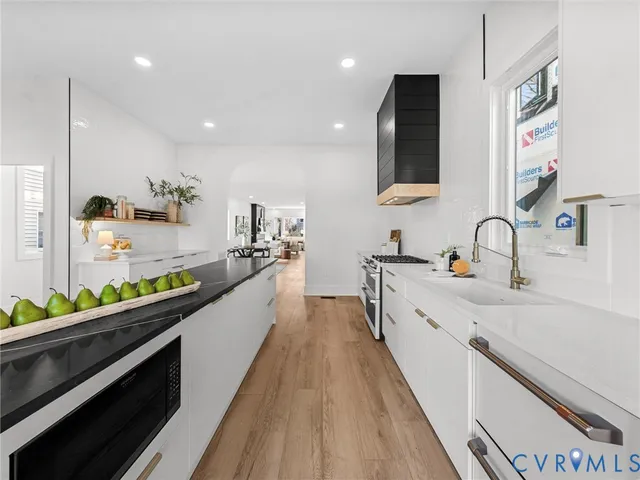 a large kitchen with stainless steel appliances kitchen island granite countertop a sink and cabinets
