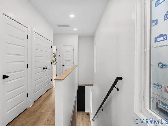 a view of hallway with stairs and wooden floor