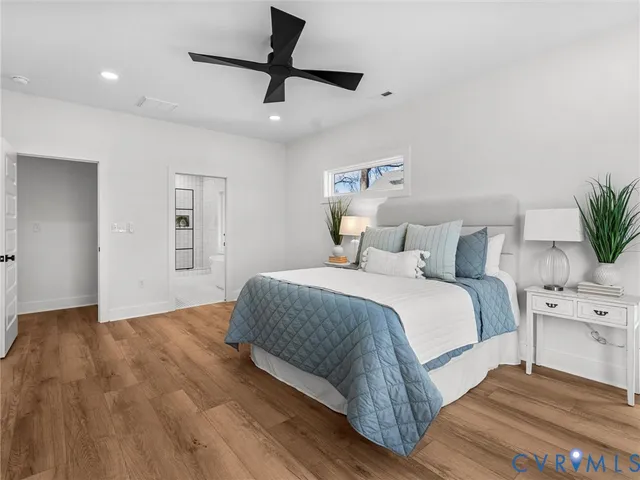 a bedroom with a bed and a potted plant on the dresser