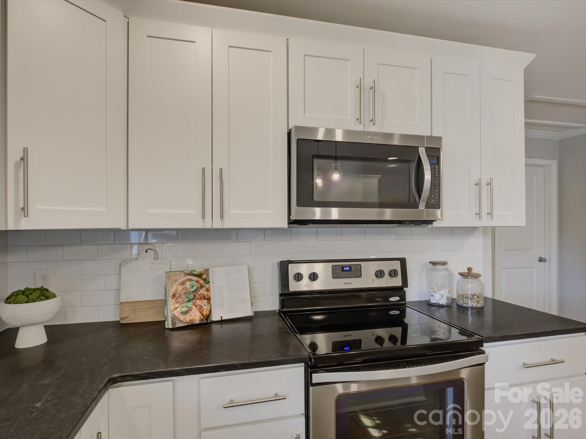 204 West Elliott Street Fort Mill, SC 29715 - Photo 13 of 43 a kitchen with stainless steel appliances granite countertop white cabinets and a stove a oven with white countertops