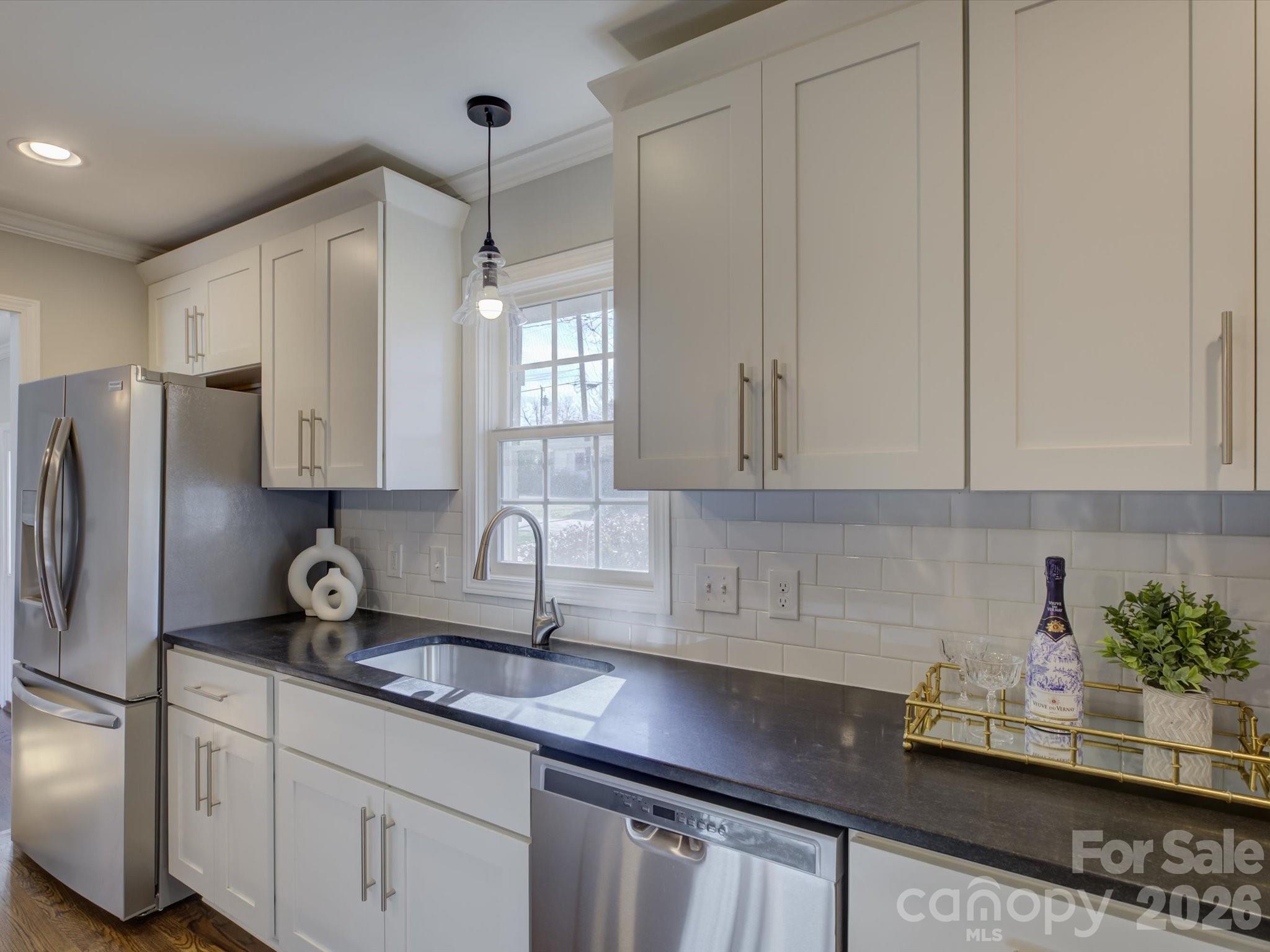 204 West Elliott Street Fort Mill, SC 29715 - Photo 14 of 43 a kitchen with stainless steel appliances granite countertop a sink a refrigerator and cabinets