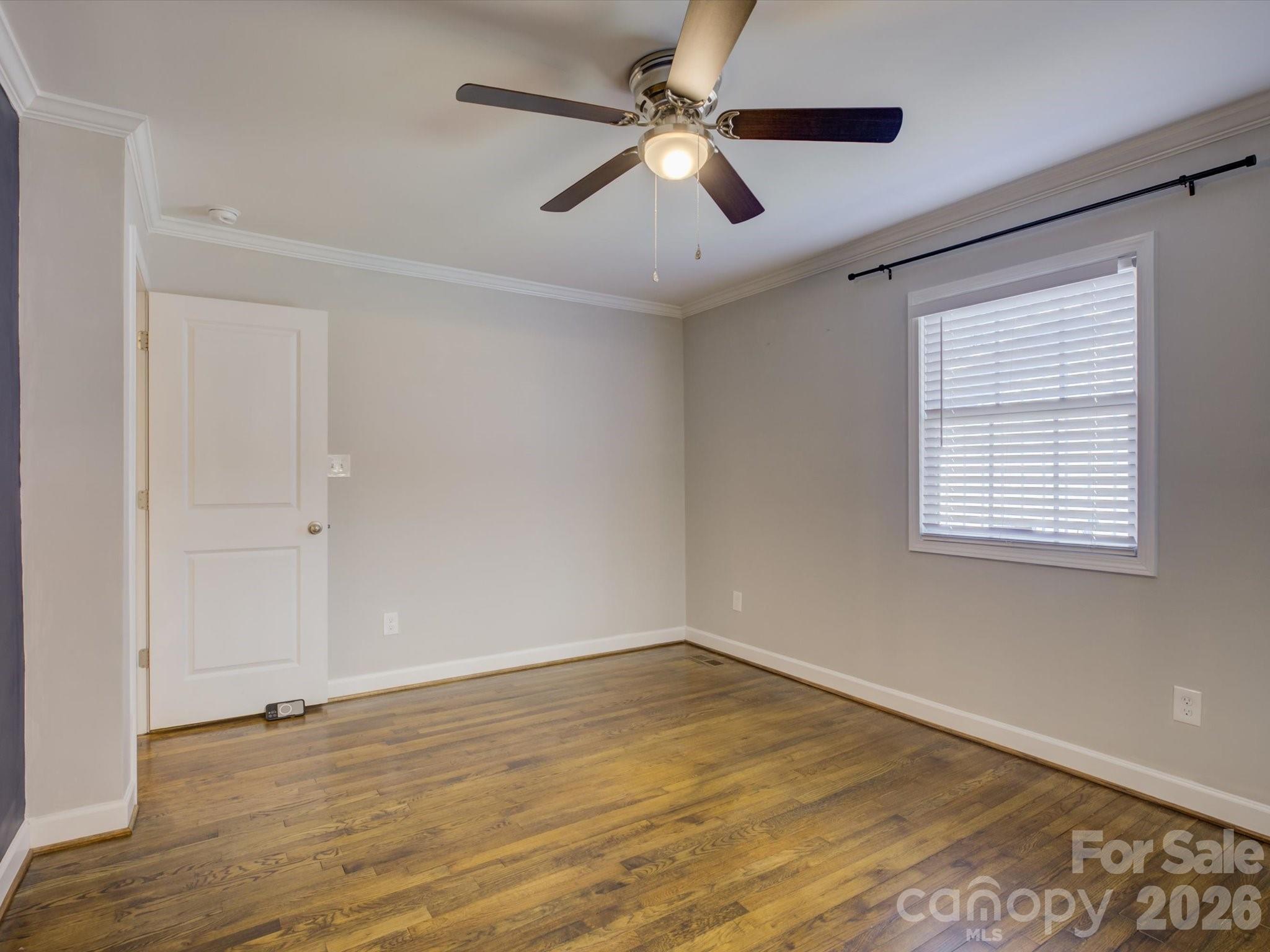 204 West Elliott Street Fort Mill, SC 29715 - Photo 20 of 43 an empty room with wooden floor fan and windows