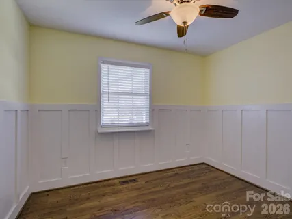 a view of an empty room with window and a ceiling fan