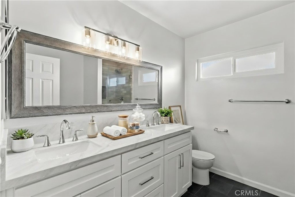 7425 Garden Grove Avenue Reseda, CA 91335 - Photo 7 of 12 a bathroom with a granite countertop sink mirror and toilet