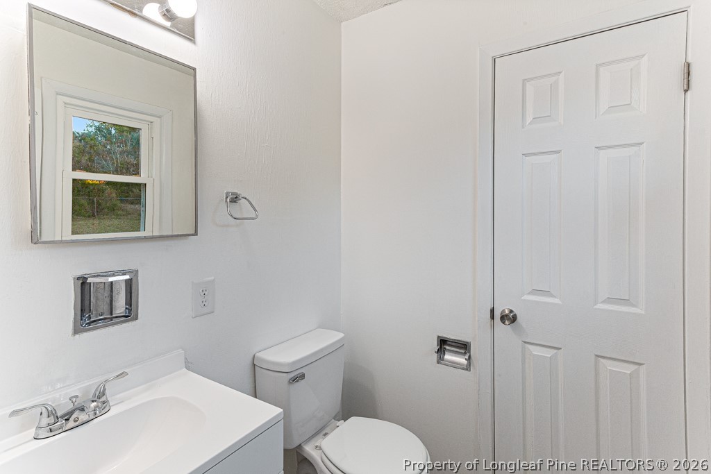 922 Rancho Drive Fayetteville, NC 28303 - Photo 21 of 21 a bathroom with a toilet a sink and mirror