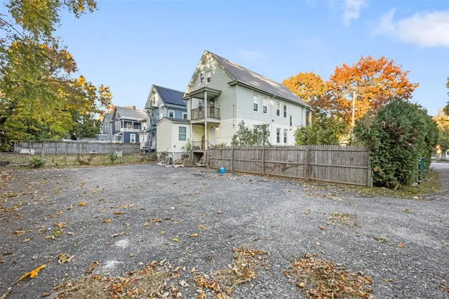 a view of a house with a yard and wooden fence