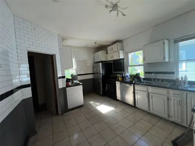 a large kitchen with a refrigerator a stove top oven a sink dishwasher and a refrigerator