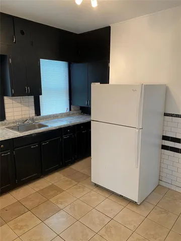 a kitchen with a sink a refrigerator and a stove top oven