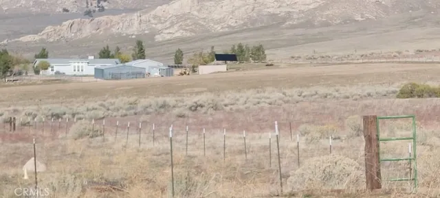 a view of a dry yard with wooden fence