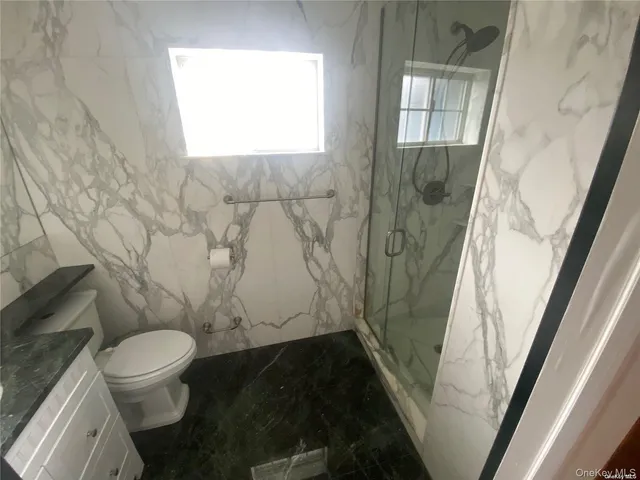 a bathroom with a toilet and a shower