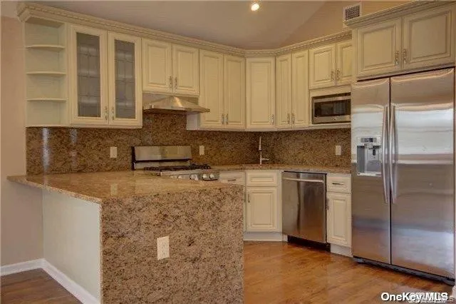 a kitchen with a refrigerator stove and cabinets