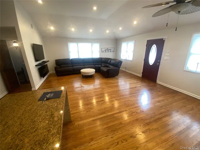a living room with patio furniture and a wooden floor