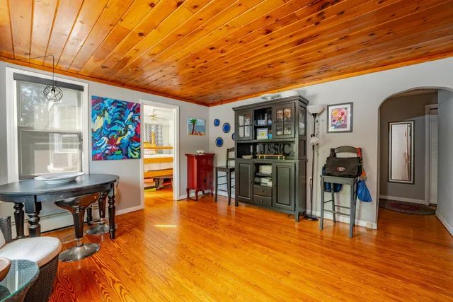 a living room with stainless steel appliances kitchen island granite countertop furniture and a wooden floor
