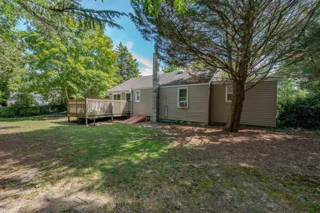 a view of a house with backyard and tree