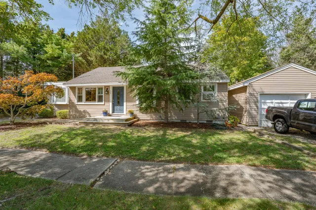 a view of a yard with a house and a large tree