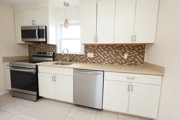 a kitchen with granite countertop white cabinets stainless steel appliances and sink