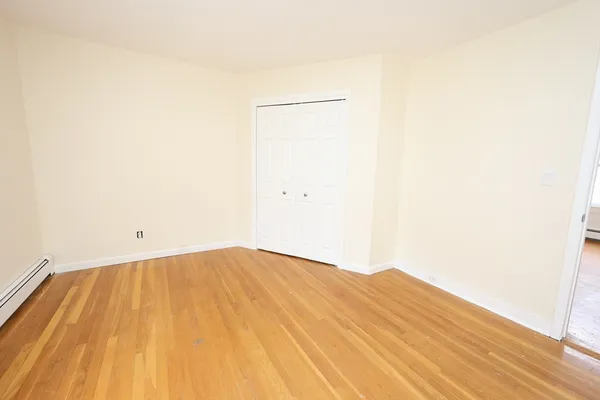 a view of empty room with wooden floor