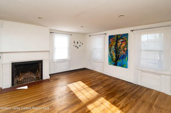 a view of an empty room with window and fire place