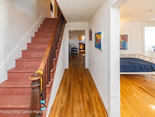 a view of a hallway with wooden floor and staircase