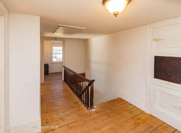 a view of a hallway with wooden floor and staircase