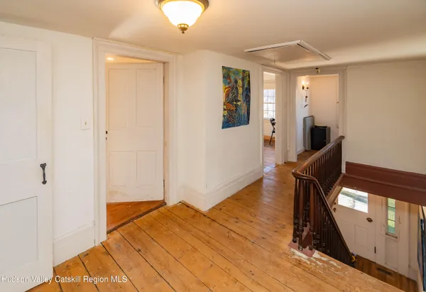 a view of a livingroom with wooden floor and staircase