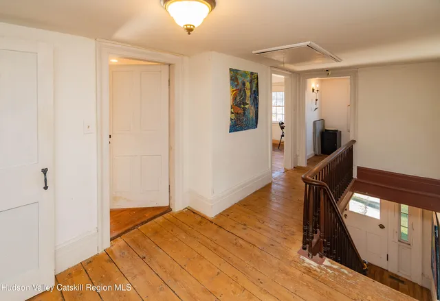 a view of a livingroom with wooden floor and staircase