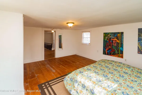 a bedroom with a bed and painting on the wall
