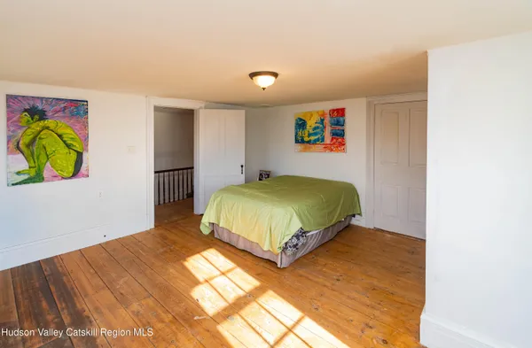 a bedroom with a bed and a painting on the wall