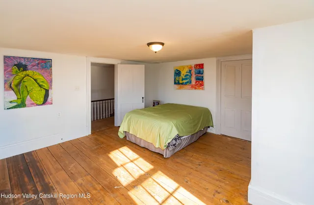 a bedroom with a bed and a painting on the wall