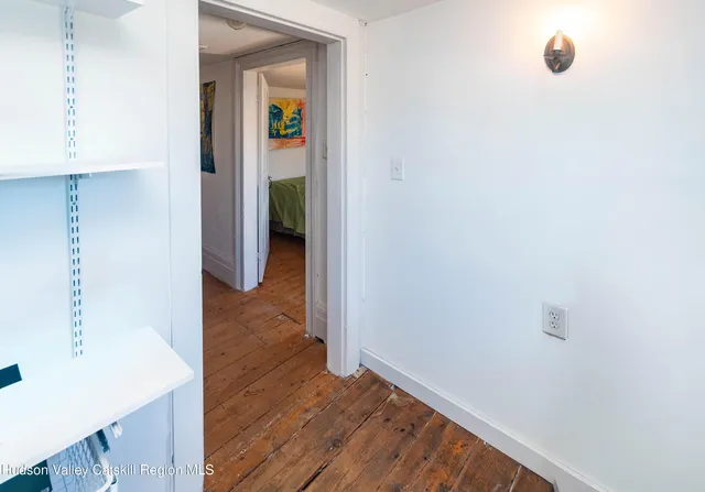 a view of a hallway with wooden floor and closet