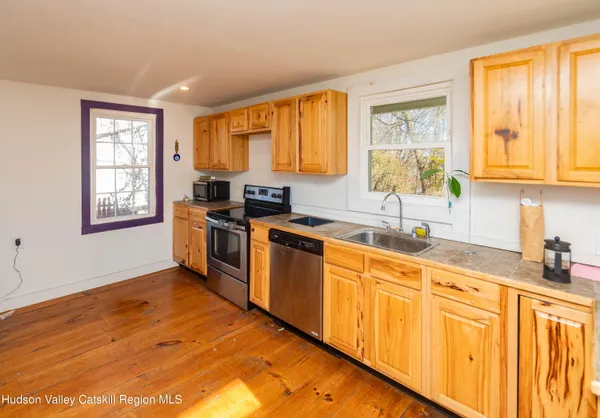 a kitchen with stainless steel appliances sink cabinets and window