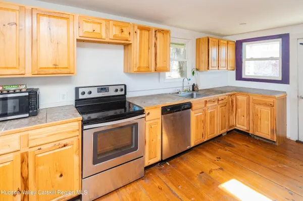 a kitchen with stainless steel appliances granite countertop a sink a stove cabinets and wooden floor