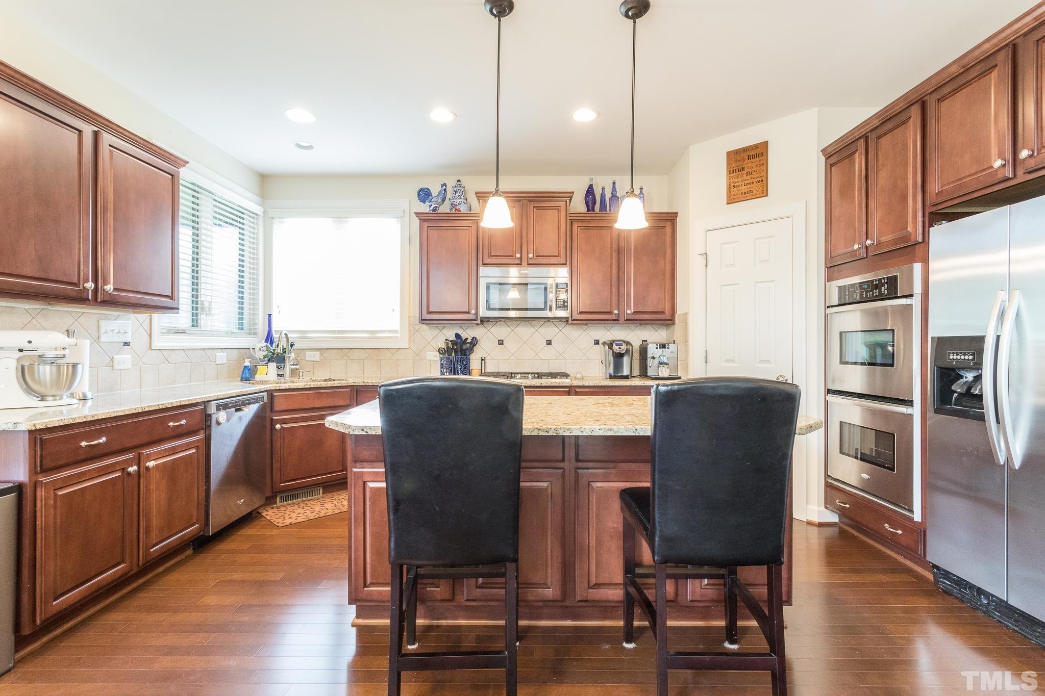 2800 Bending Tree Court Raleigh, NC 27613 - Photo 21 of 49 a kitchen with stainless steel appliances granite countertop a table chairs microwave and sink