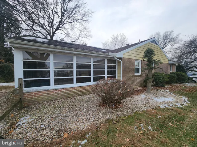 a front view of a house with a large window and potted plants