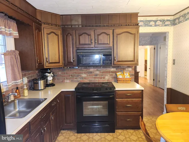 a kitchen with granite countertop a sink stainless steel appliances and cabinets