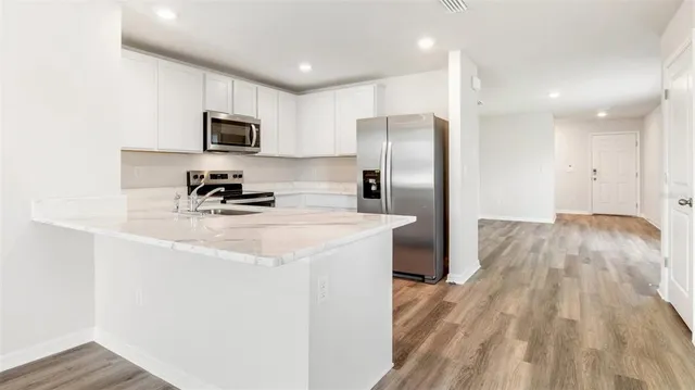 a kitchen with stainless steel appliances a refrigerator a sink a stove a microwave and cabinets