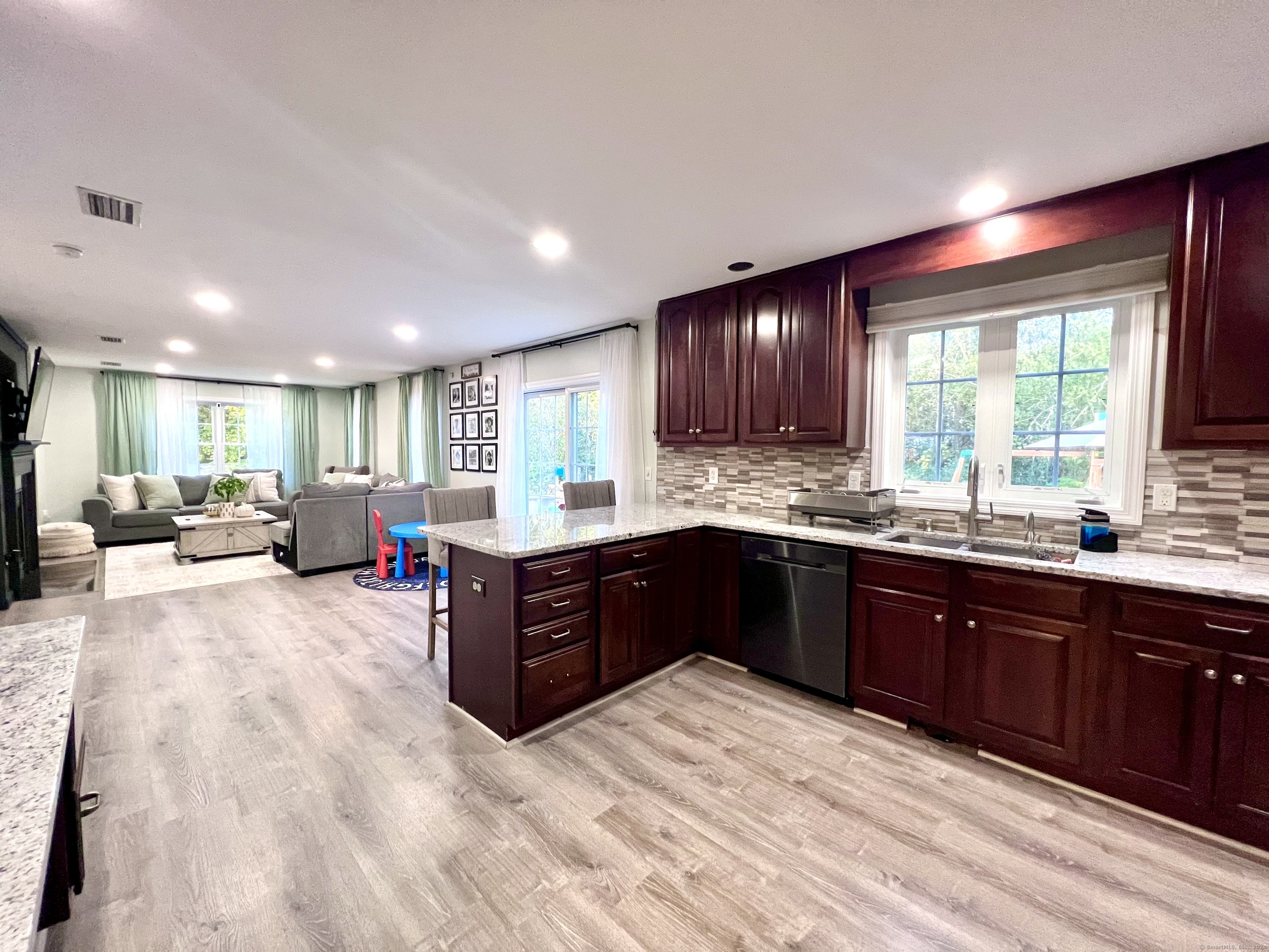 4 Cobblestone Court Naugatuck, CT 06770 - Photo 11 of 34 a large kitchen with stainless steel appliances granite countertop a refrigerator a sink dishwasher a dining table and chairs with wooden floor