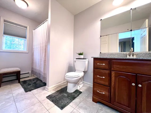 a spacious bathroom with a toilet a sink and a mirror