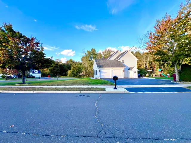 a view of a house with a big yard and large trees