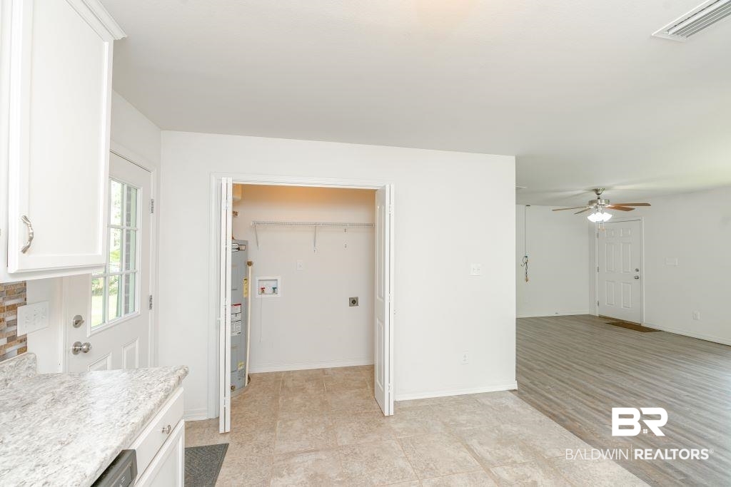 12641 Pecan Street Grand Bay, AL 36541 - Photo 12 of 23 Kitchen with water heater, white cabinetry, ceiling fan, and light wood-type flooring