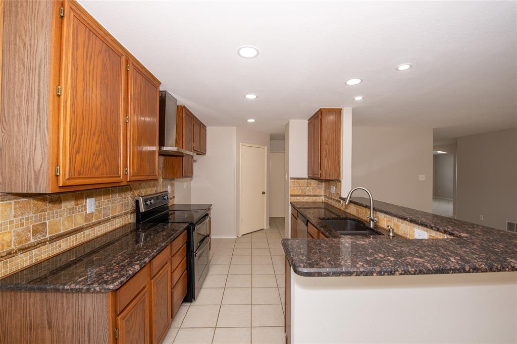 1157 Whistle Saginaw, TX 76131 - Photo 8 of 33 a kitchen with kitchen island granite countertop a sink and counter top space